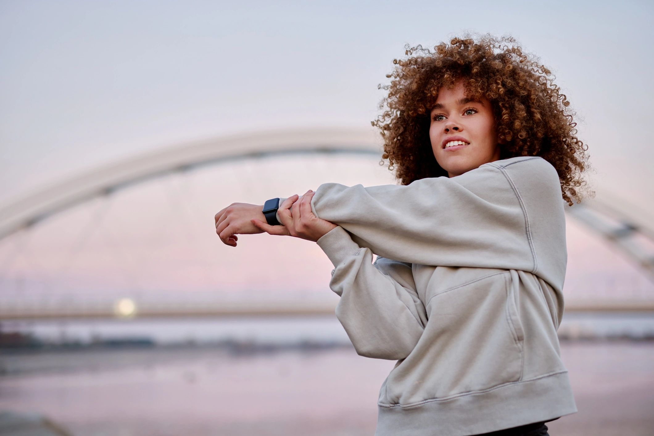 Person stretching outdoors at sunrise